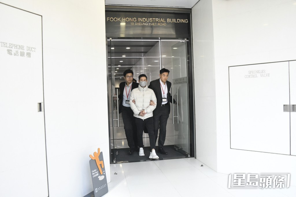 男子雙手被鎖上手銬。楊偉亨攝