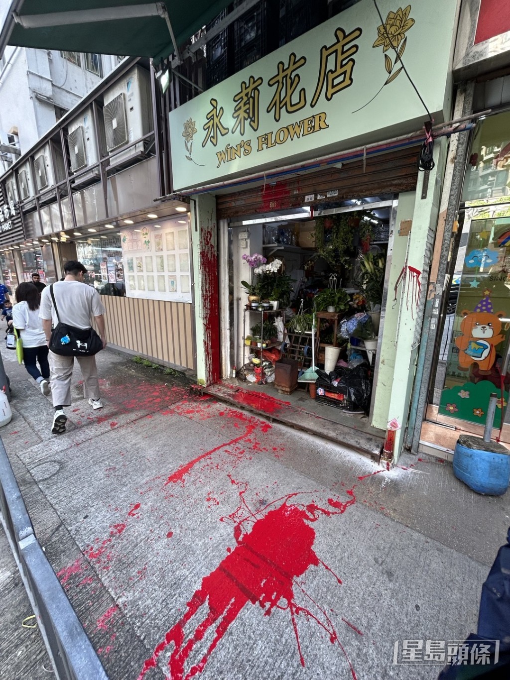 花店鐵閘遭淋紅油，行人路亦波及。楊偉亨攝