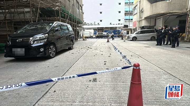 工廈外牆石屎墮下，砸傷女途人並擊毀七人車。劉漢權攝
