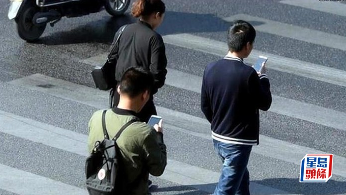 澳門擬修例禁行人過馬路時使用手機 違例可罰款300元。資料圖片