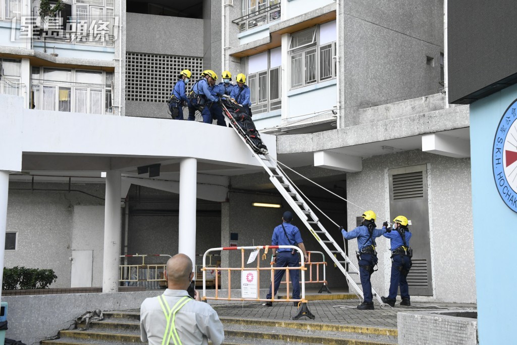 消防員利用長梯及擔架,將女死者的遺體由平台移住地面。楊偉亨攝 消防員利用長梯及擔架,將女死者的遺體由平台移住地面。楊偉亨攝