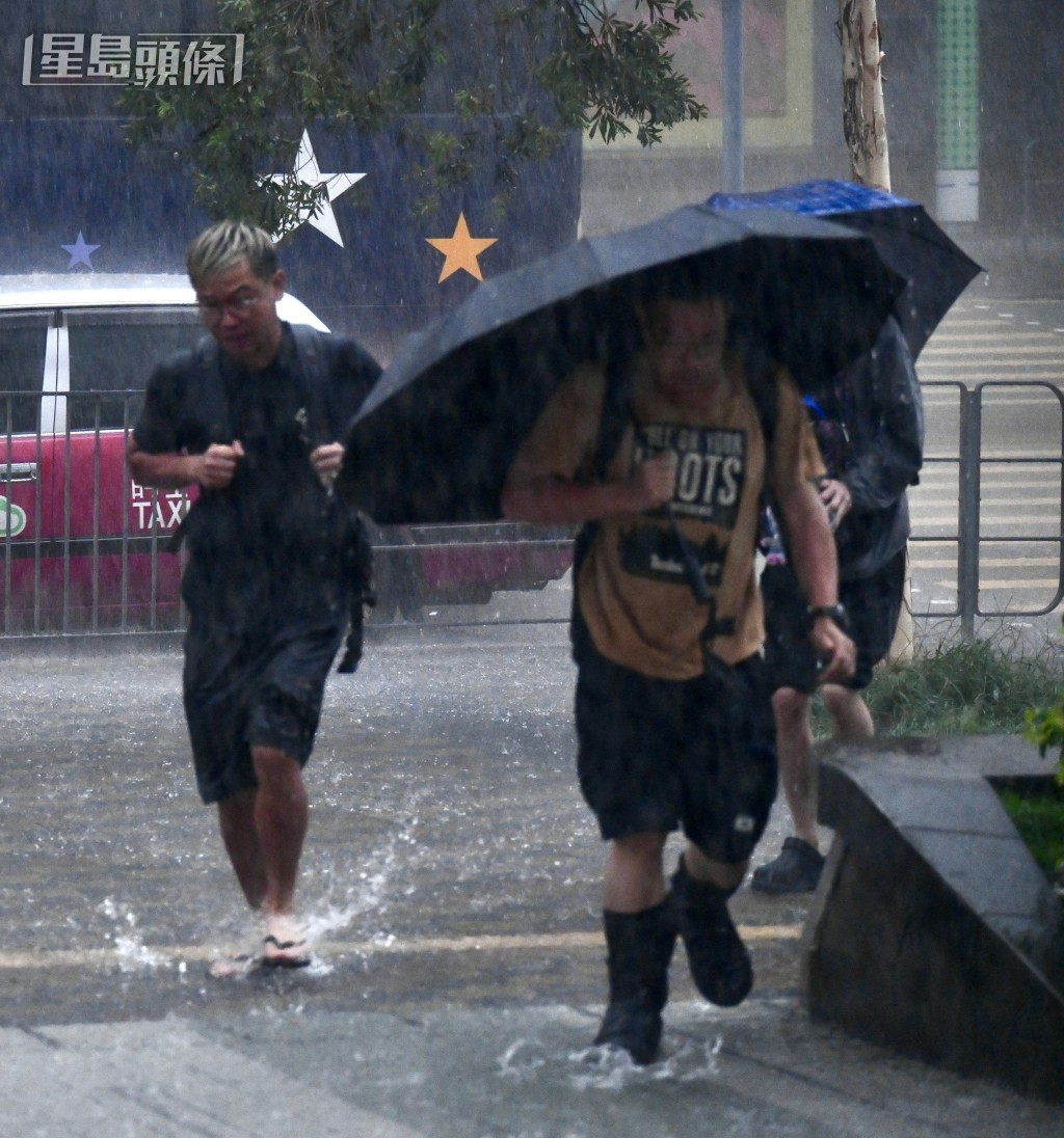 天文台於7:50分發出黑色暴雨警告，有市民冒着暴雨上班。盧江球攝
