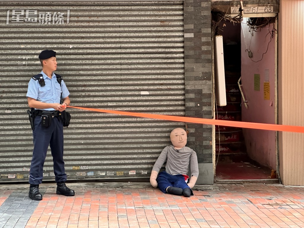 被告巫泰峯(白衣蒙頭)被捕後被帶返現場重組案情。資料圖片 被告巫泰峯(白衣蒙頭)被捕後被帶返現場重組案情。資料圖片