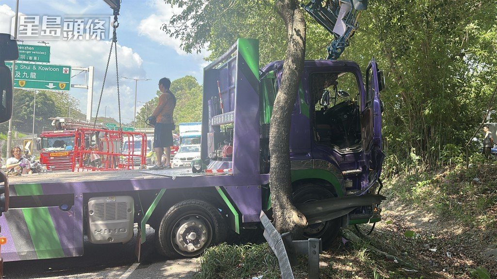 拖架貨車撞毀鐵欄剷入草叢。劉漢權攝 拖架貨車撞毀鐵欄剷入草叢。劉漢權攝