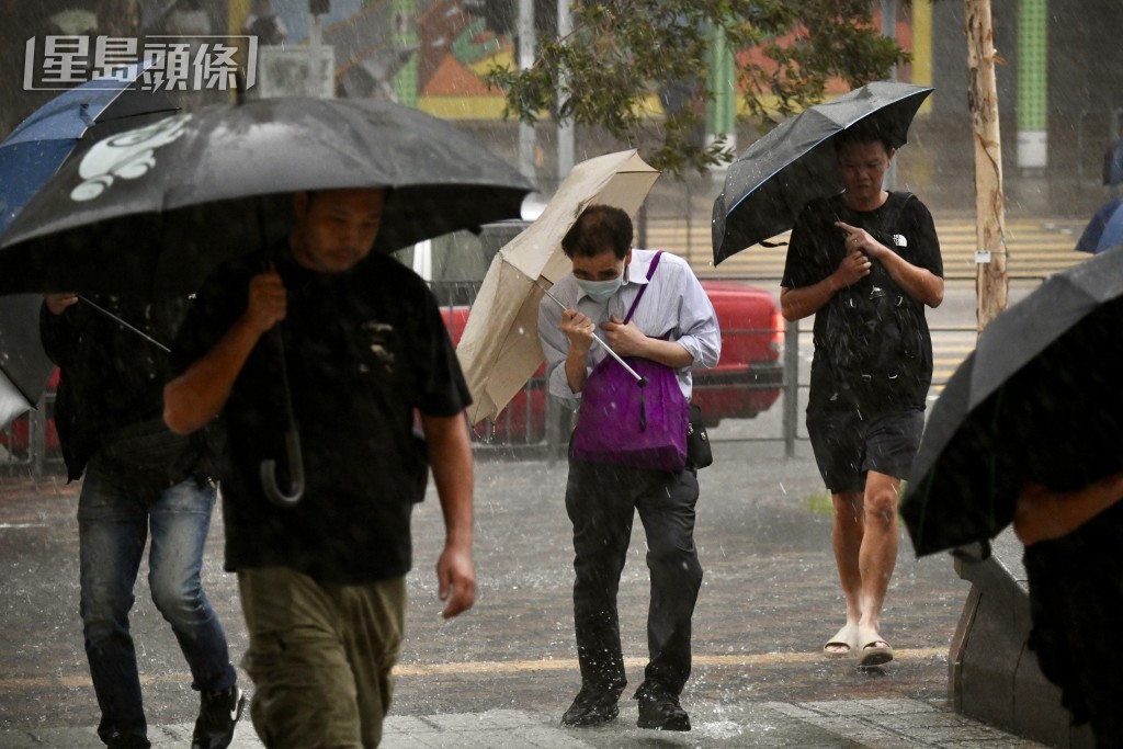 黑雨下市民狼狽前行。盧江球攝