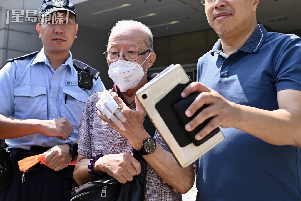 何伯離庭時由警員開路。劉駿軒攝 何伯離庭時由警員開路。劉駿軒攝