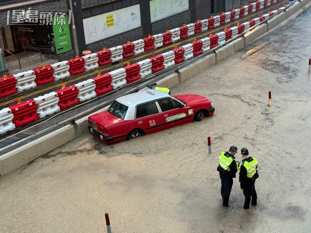 青山公路葵涌段有的士被困水中。