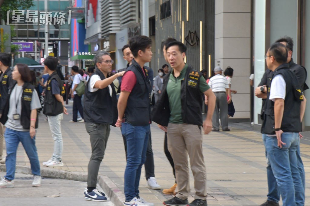 警方押解疑犯返回現場重組案情。