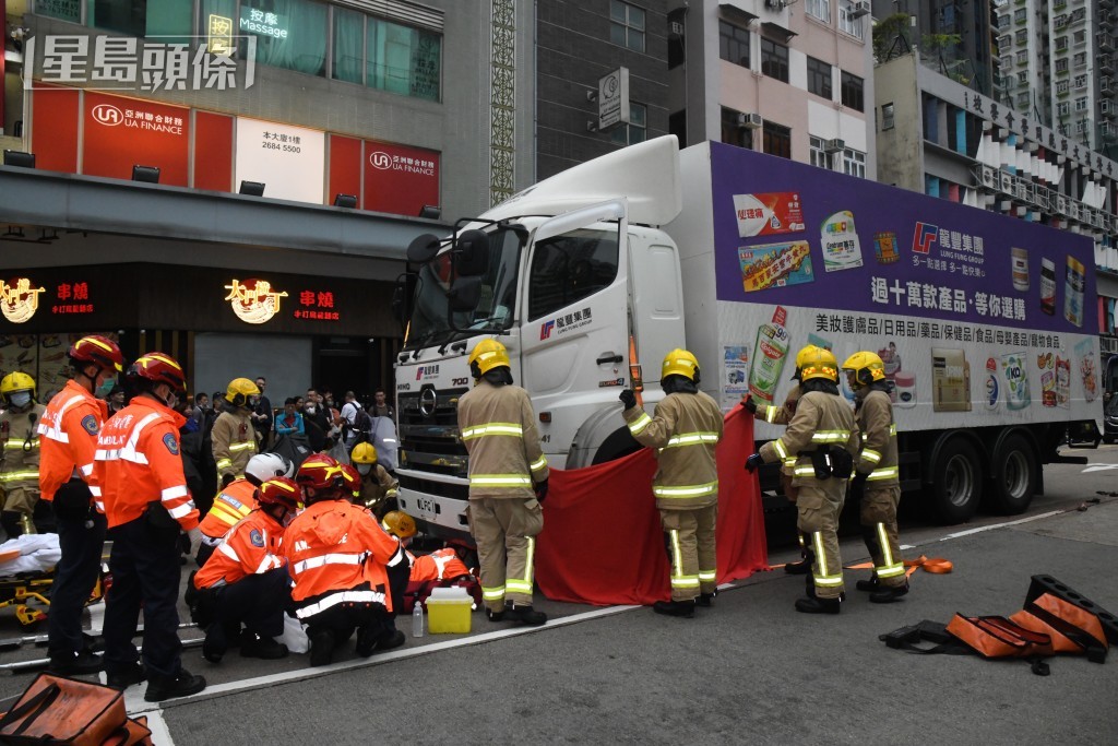 消防在現場拯救被捲車底的死者。資料圖片