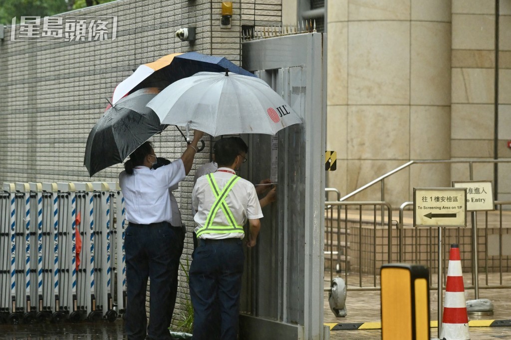 法庭保安於閘外張貼黑色暴雨警告生效告示。劉駿軒攝