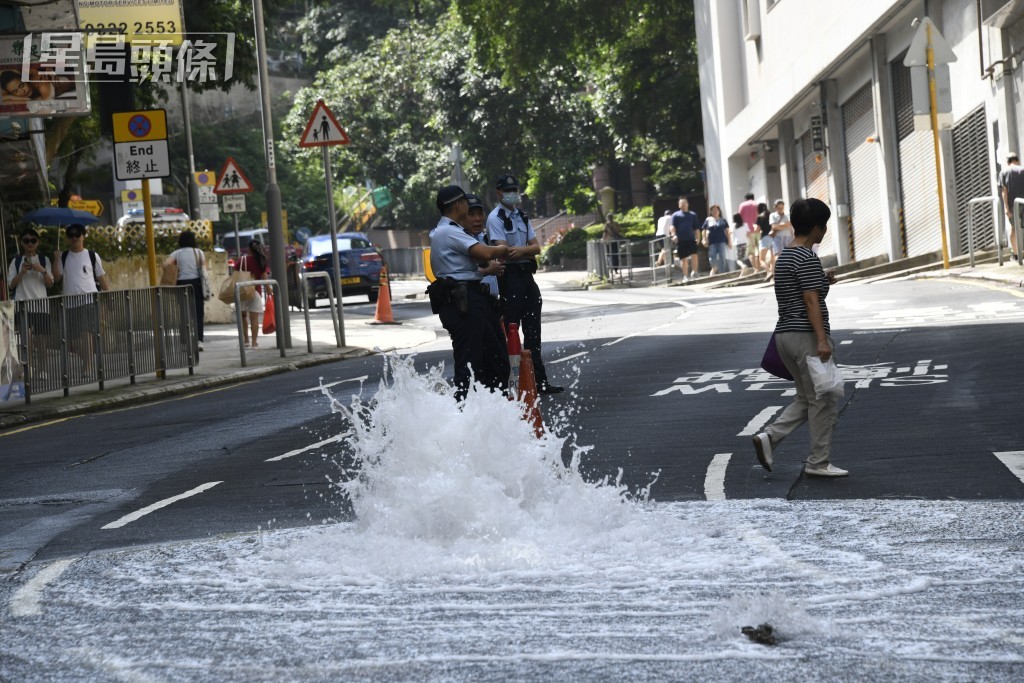 炮台山道爆地底鹹水管，警員到場處理。楊偉亨攝