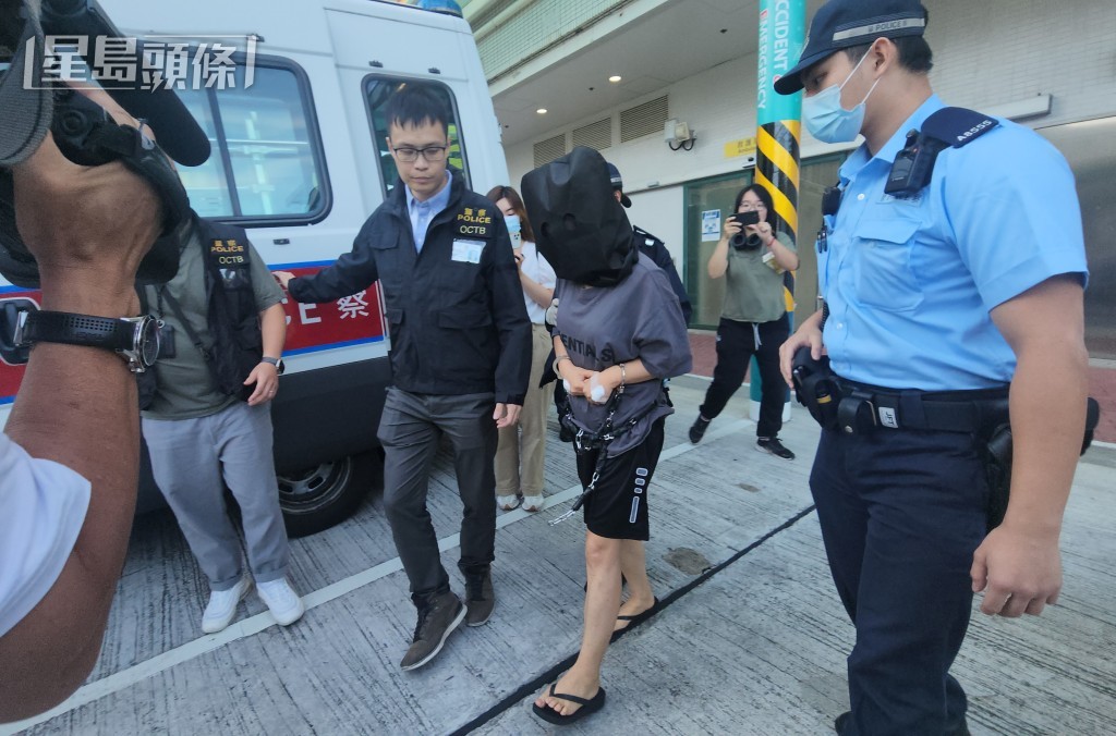 女綁匪離開醫院時被黑布蒙頭、腰間纏上鎖鏈。黃文威攝