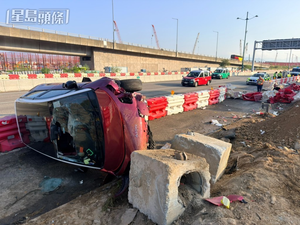兩車相撞,其中一輛私家車翻側。 兩車相撞,其中一輛私家車翻側。