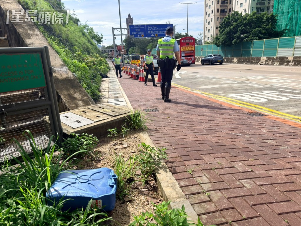 較早前事故遺下藍色膠桶，警車停泊在場處理期間，被私家車失事撞尾。