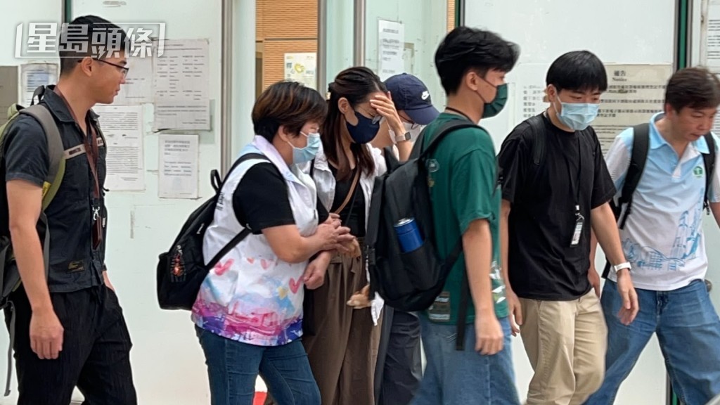 遺孀一臉哀傷，需要攙扶離開。