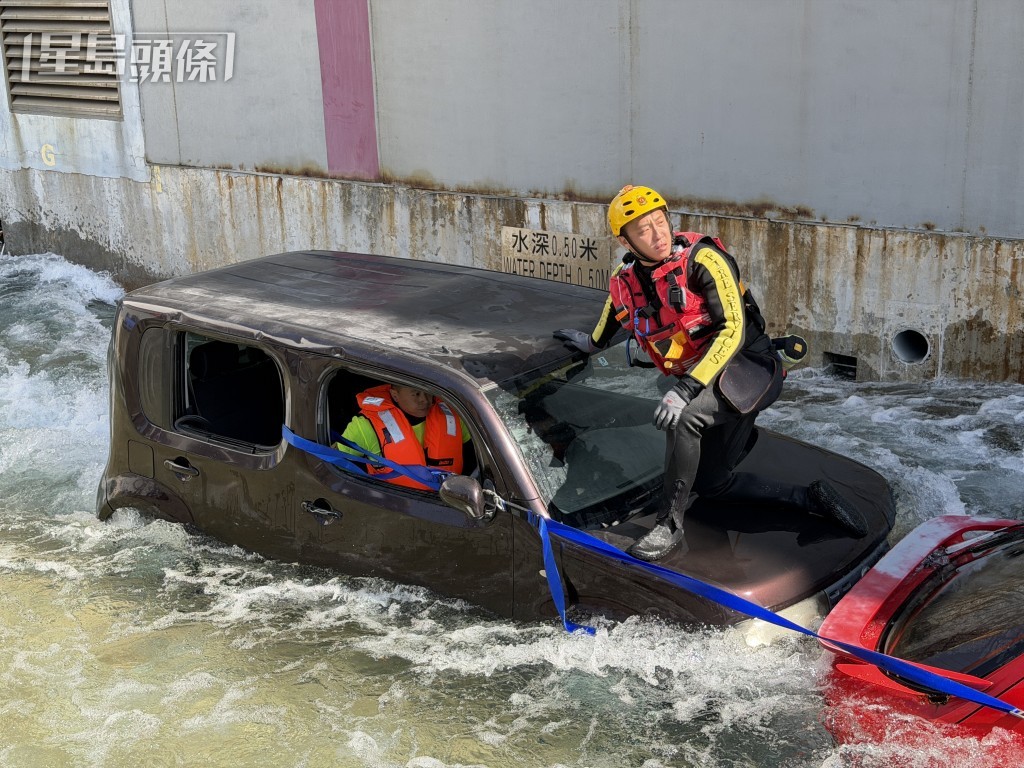 拯救隊成員示範如何在掉進水裏的車輛中救人。 拯救隊成員示範如何在掉進水裏的車輛中救人。