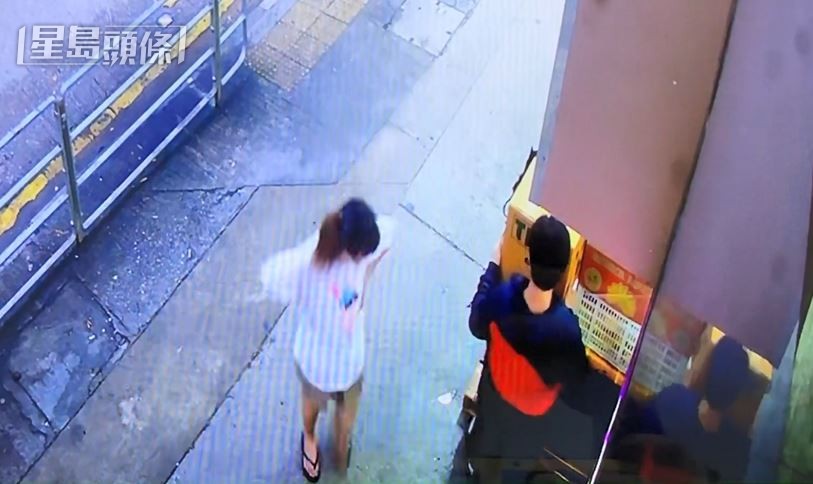男子搬走生果，疑为同党的白衫女子在旁查看。梁国峰摄