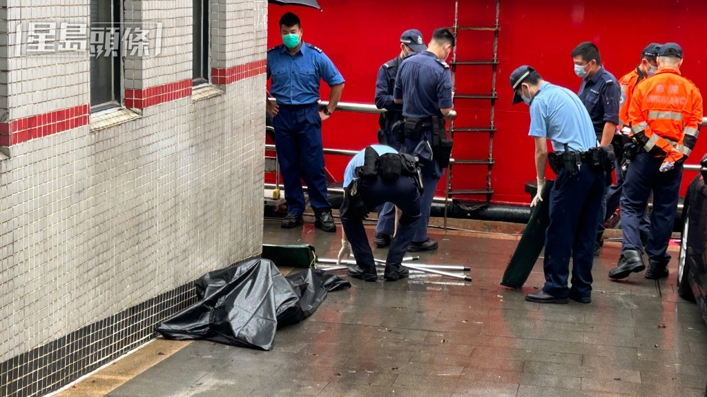 人員用黑膠袋包裹死者遺體。
