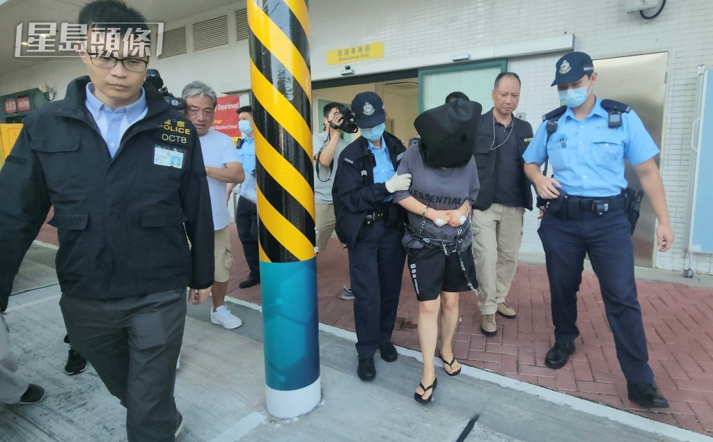 女綁匪離開醫院時被黑布蒙頭、腰間纏上鎖鏈。黃文威攝