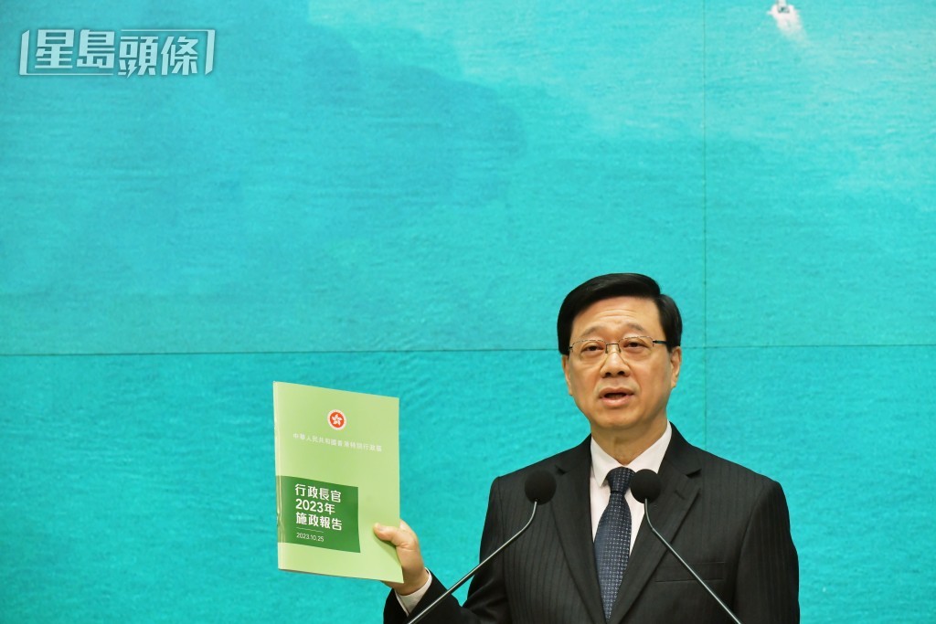 李家超昨出席行政會議前，展示新一份《施政報告》。陳極彰攝