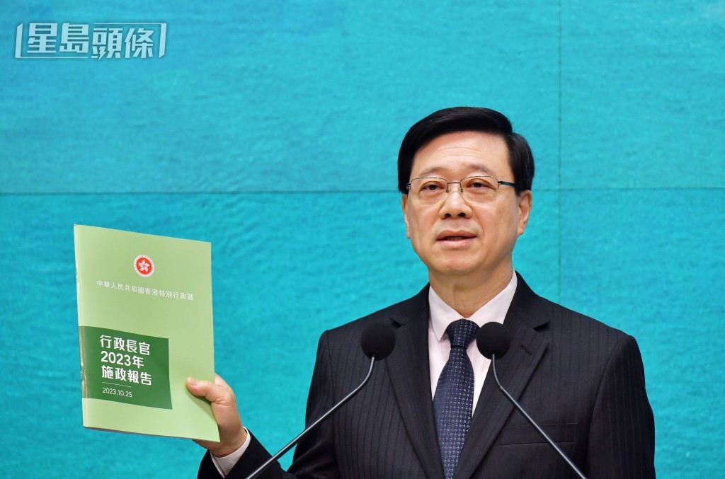 李家超昨出席行政會議前，展示新一份《施政報告》。陳極彰攝