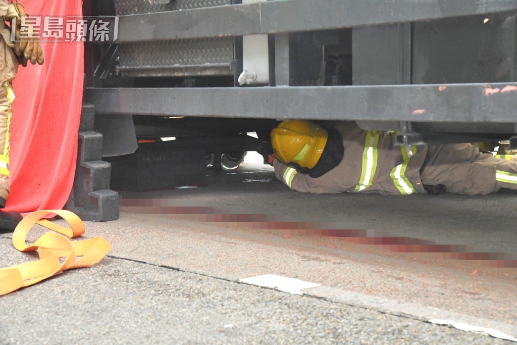 消防於車底進行拯救。資料圖片
