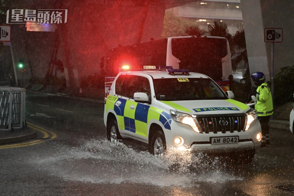 西九龍裁判法院外有輕微積水，警車經過濺起地上水花。