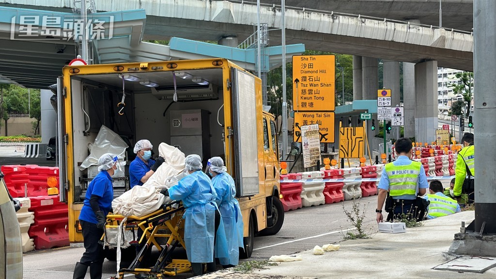 仵工將遺體移離現場。梁國峰攝