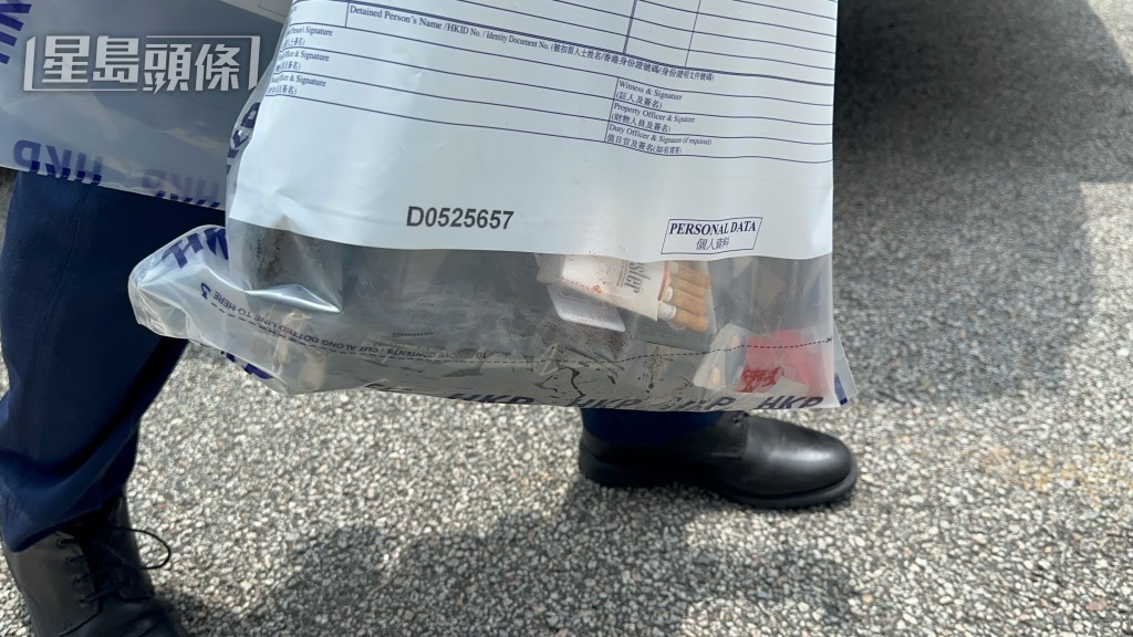警員檢獲墮樓男子的個人物品。 警員檢獲墮樓男子的個人物品。