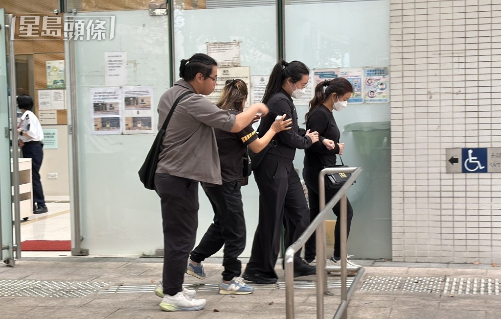 死者家屬在工權會代表（左）陪同下，到葵涌殮房認領遺體。梁國峰攝