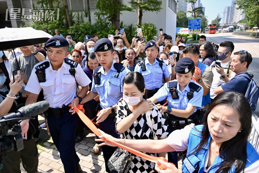 何太在警方拉起橙帶開路下離開法庭。劉駿軒攝 何太在警方拉起橙帶開路下離開法庭。劉駿軒攝