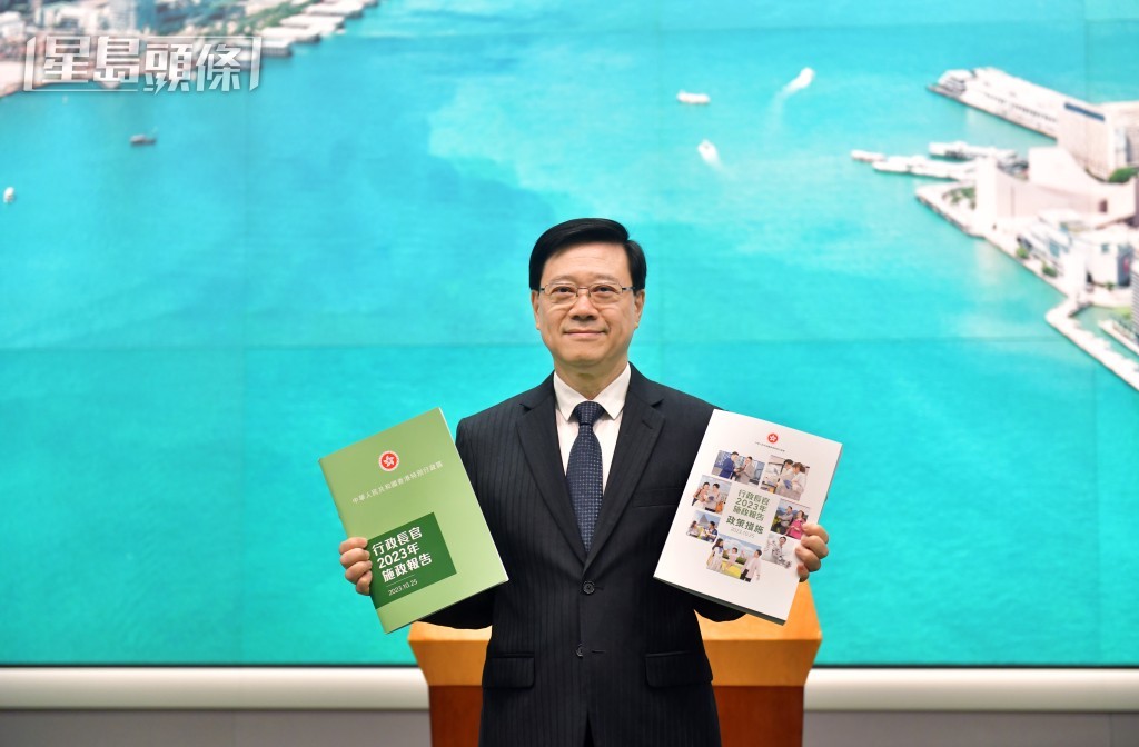 李家超昨出席行政會議前，展示新一份《施政報告》。陳極彰攝