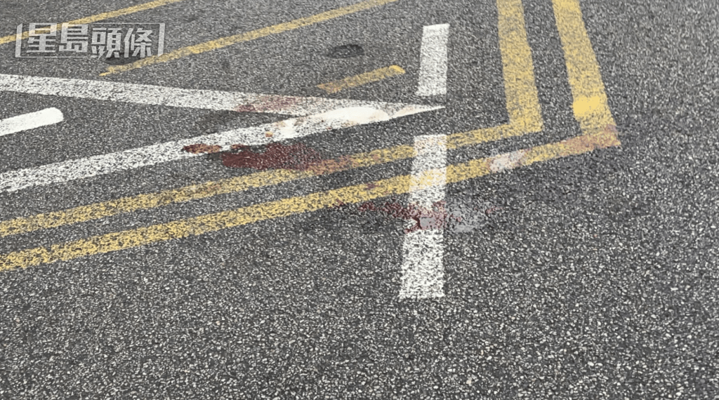 死者墮樓的馬路上,遺下明顯血迹,警方用膠帶圍封現場。 死者墮樓的馬路上,遺下明顯血迹,警方用膠帶圍封現場。