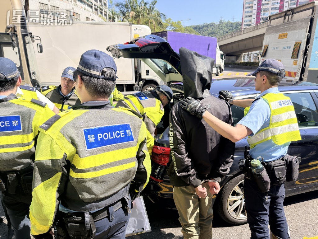 男司機被警員以黑布蒙頭。
