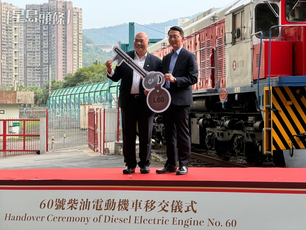 港鐵車務及創新總監李家潤（左）將60號柴油電動機車鎖匙移交給康文署署長劉明光（右）。謝宗英攝