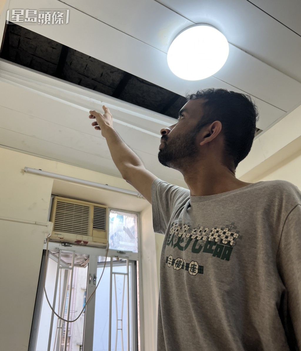 楼下住户Mehmood拆开假天花，指示裂痕位置。刘汉权摄