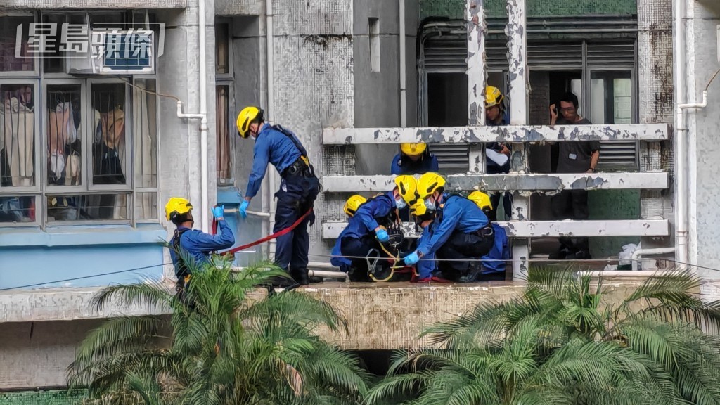消防員在大廈平台處理死者遺體。 消防員在大廈平台處理死者遺體。