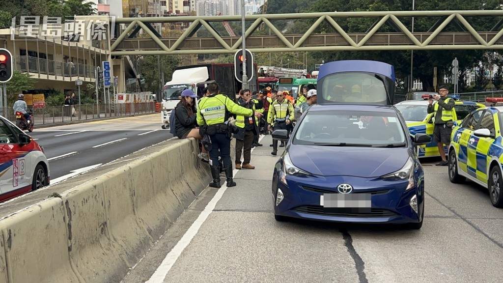 蓝色私家车途经现场，司机停车向警方提供资料。