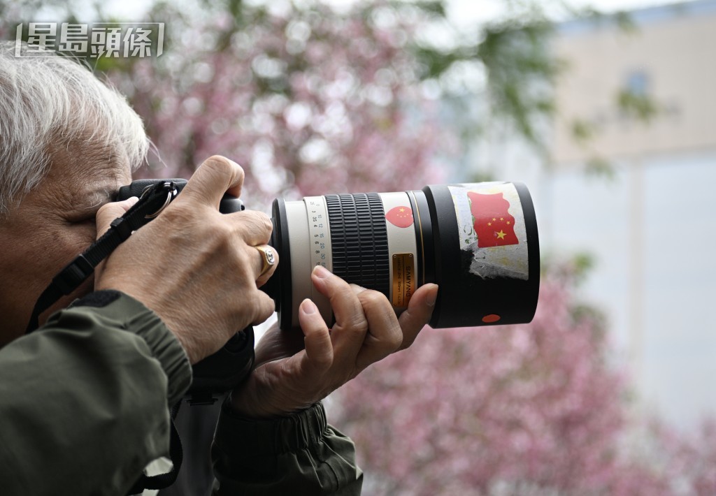 有市民帶長鏡頭影櫻花。 有市民帶長鏡頭影櫻花。
