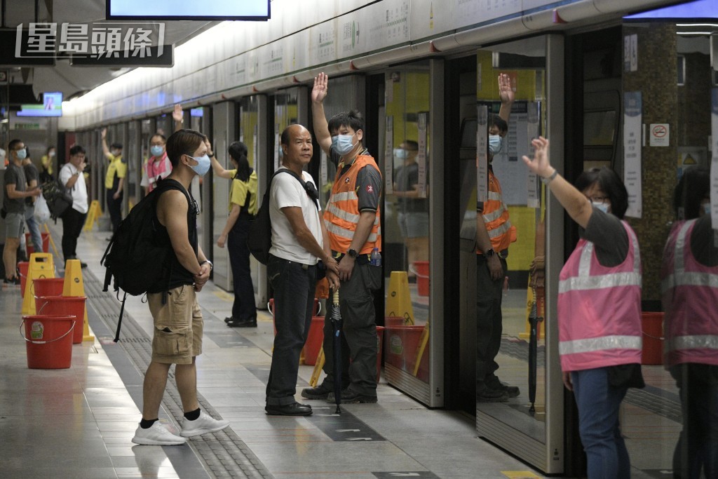 月台幕門被打開後，每道門均有月台助理在場，開車前舉手示意沒有乘客靠近列車。(陳浩元攝)