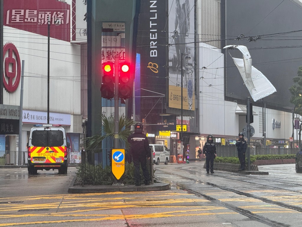膠板掛在電車路的架空電纜上，警員在場處理。