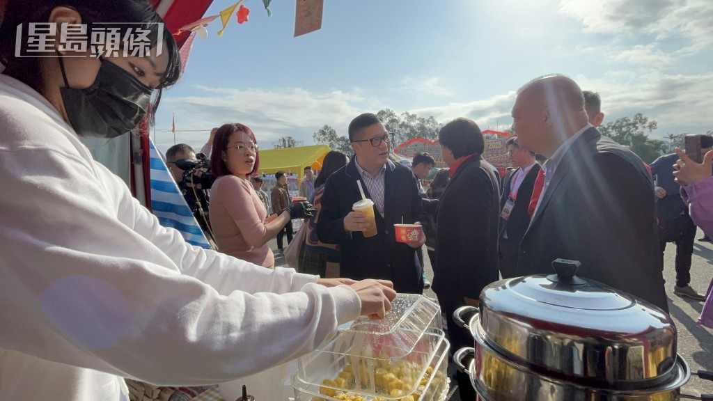 鄧炳強向林村攤檔檔販購買小食。林思明攝