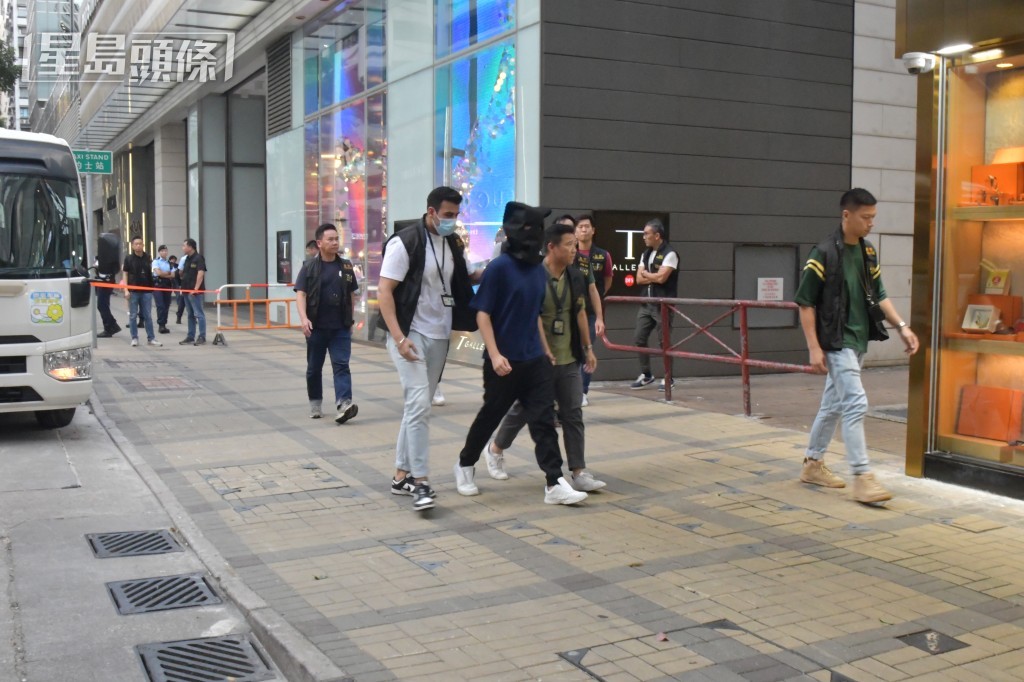 警方押解疑犯返回現場重組案情。