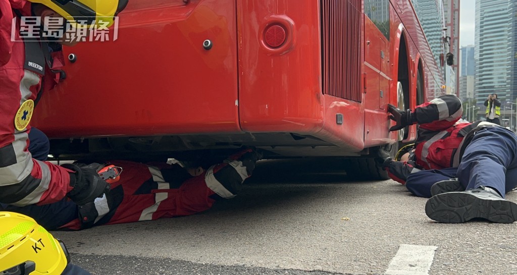 消防員爬入巴士車底救貓。林思明攝