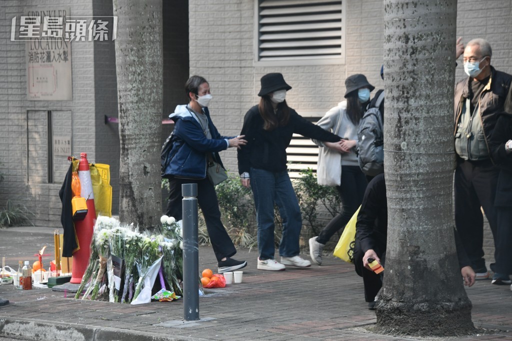 死者女友（黑衫黑帽）在路祭完畢後仍不願離開，要由同行親友拖走。梁國峰攝