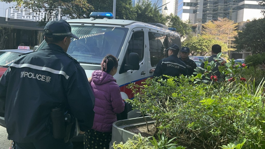 被捕女子由警員帶上警車。