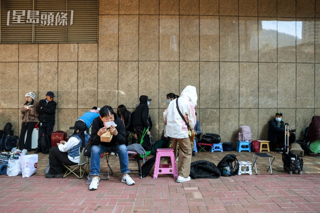 不少人用凳、紙皮、膠袋、雨傘、行李箱等物霸位代為排隊。