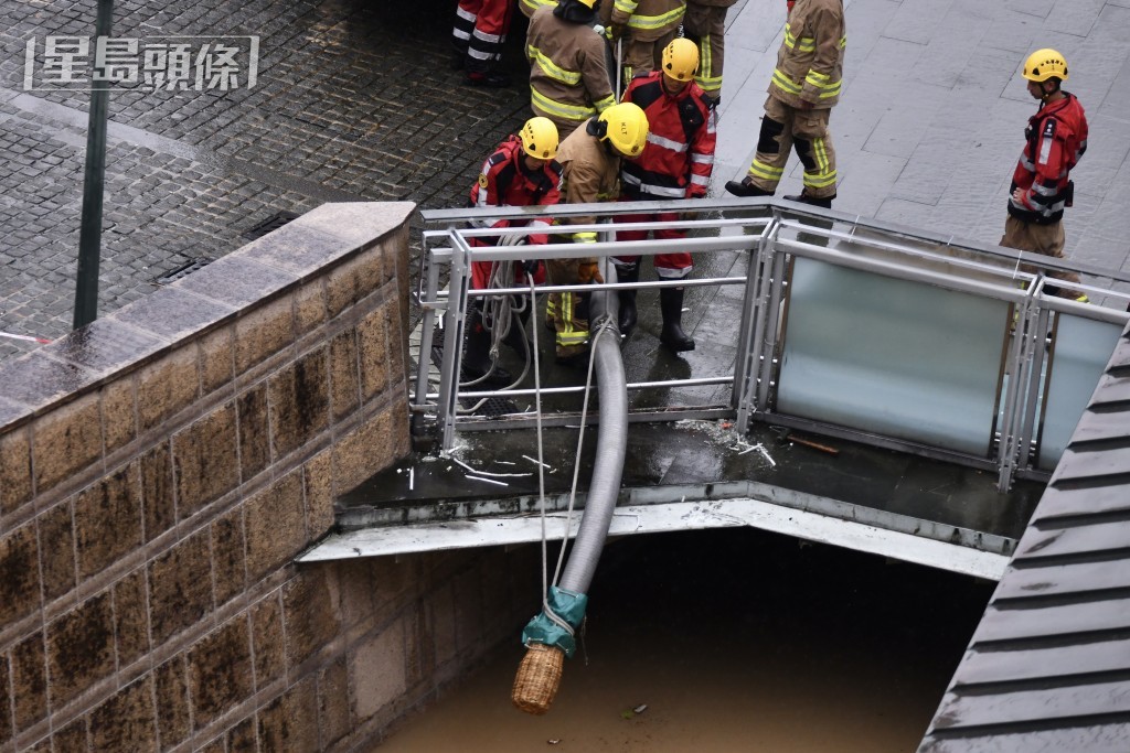 消防員在黃大仙中心外協助清理積水。 消防員在黃大仙中心外協助清理積水。