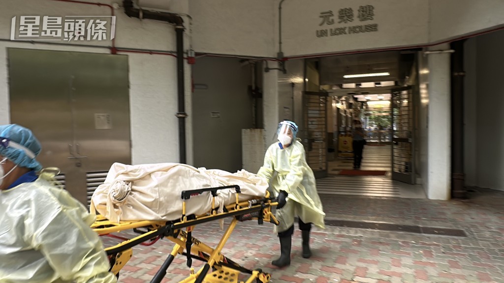 仵工將屍體移往殮房。劉漢權攝