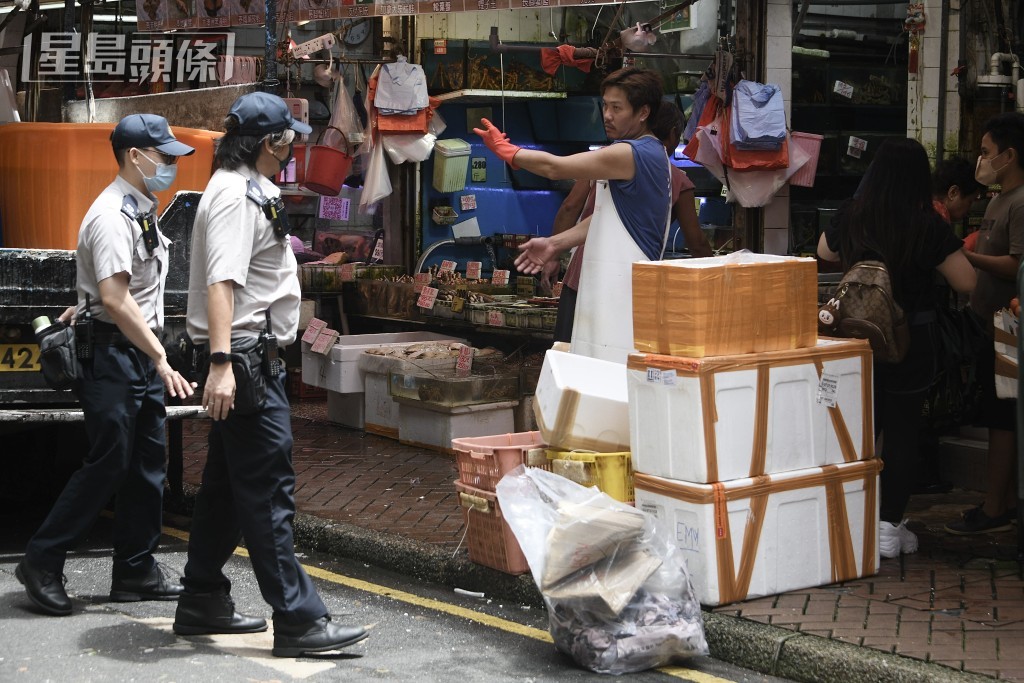 食環署職員巡視街市,提醒檔主將擺在街上的物品收起。陳浩元攝 食環署職員巡視街市,提醒檔主將擺在街上的物品收起。陳浩元攝